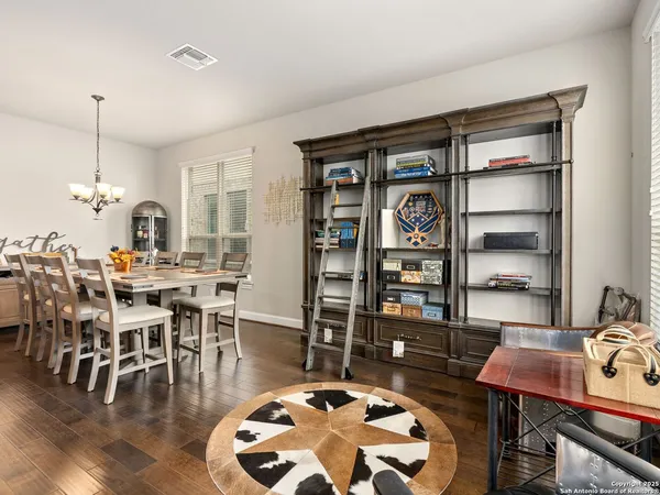 a dining room with wooden floor a glass table and chairs