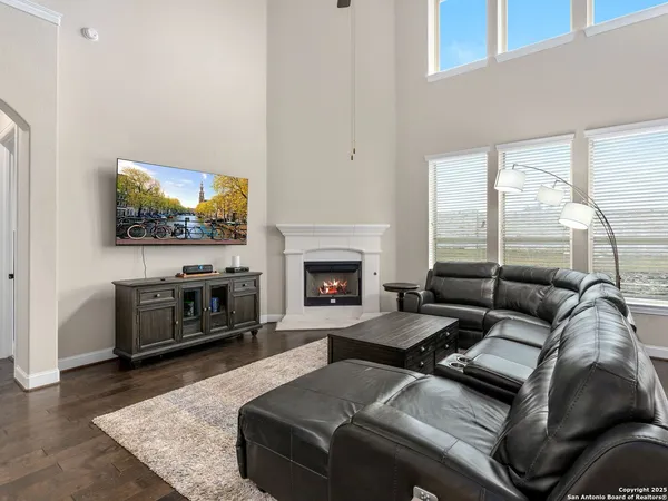 a living room with furniture a flat screen tv and a fireplace