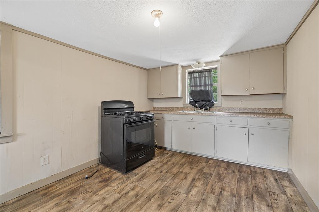 406 Carter Road Malakoff, TX 75148 - Photo 7 of 13 Wood-finish flooring, built-in cabinetry, laminate countertops, and a gas range