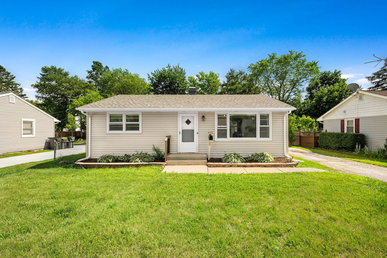 415 Alma Terrace Cary, IL 60013 - Photo 19 of 23 a front view of a house with a yard and trees