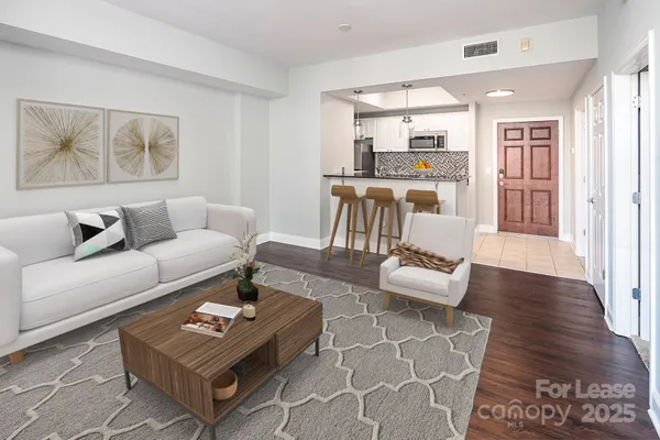 a living room with furniture and a wooden floor