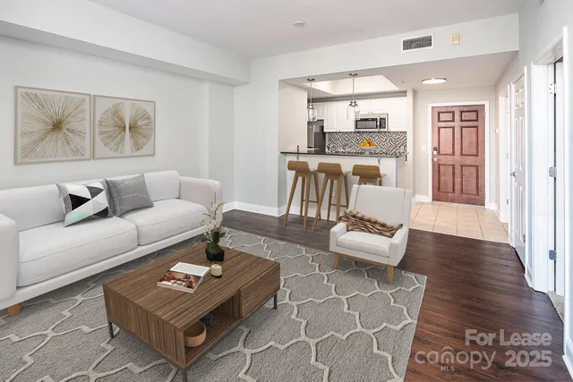 a living room with furniture and a wooden floor