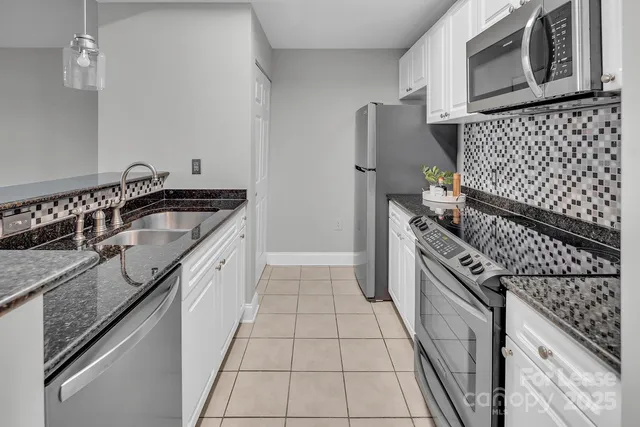 a kitchen with granite countertop cabinets and steel stainless steel appliances