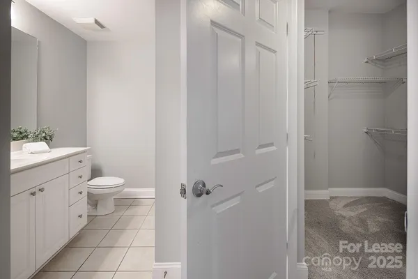 a bathroom with a granite countertop toilet a sink and a mirror