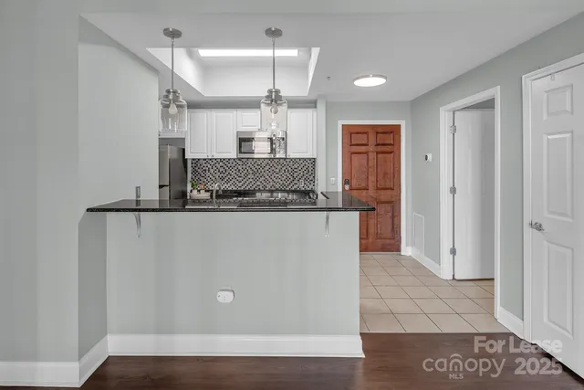 a view of a kitchen with a refrigerator and a sink