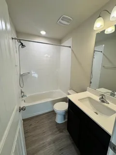 a bathroom with a sink a toilet a mirror and shower