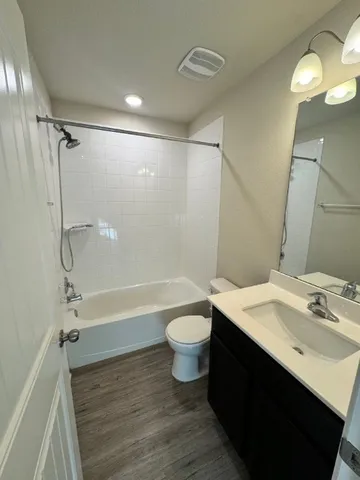 a bathroom with a sink a toilet a mirror and shower