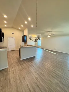 a view of a room with wooden floor and a ceiling fan