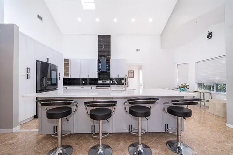 a kitchen with stainless steel appliances granite countertop a sink and a refrigerator
