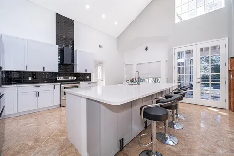 a kitchen with granite countertop a sink chairs and white appliances