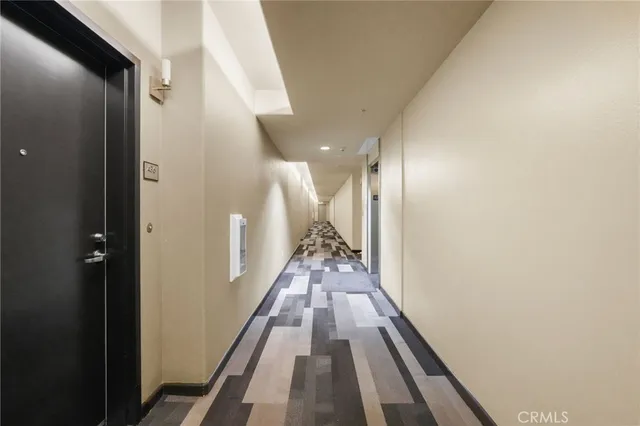 a view of an empty room with glass door and wooden floor