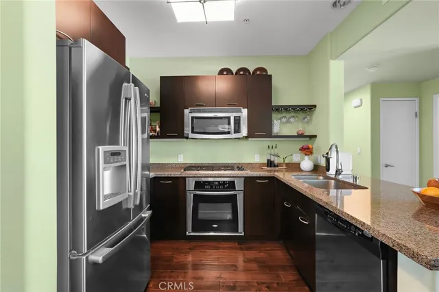 a kitchen with stainless steel appliances granite countertop a refrigerator and a stove