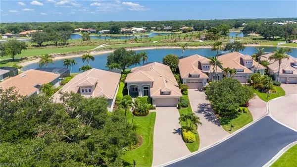 an aerial view of residential houses with outdoor space and lake view