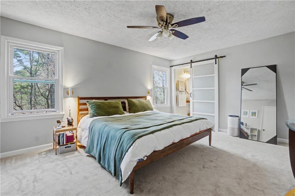 408 Candy Lane Canton, GA 30115 - Photo 12 of 22 a bedroom with a large bed and a chandelier