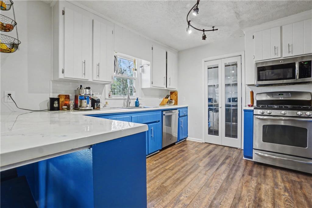 408 Candy Lane Canton, GA 30115 - Photo 8 of 22 a kitchen with stainless steel appliances a stove sink and cabinets