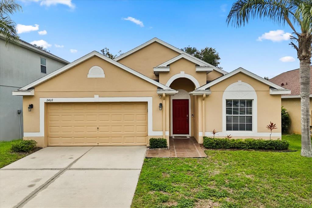 2422 Holly Pine Circle Orlando, FL 32820 - Photo 1 of 1 a front view of a house with a yard and garage