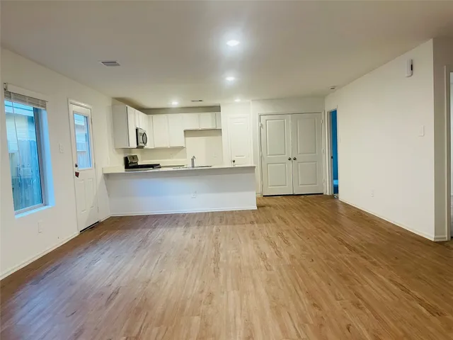 a view of a kitchen with a sink and wooden floor