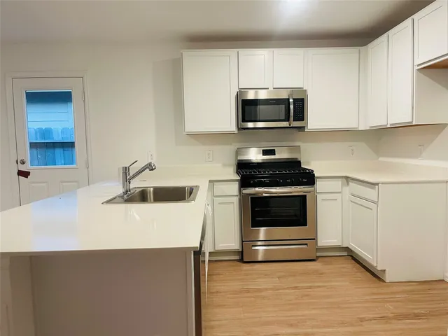 a kitchen with granite countertop a stove and a microwave