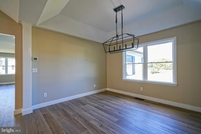 a view of a room with wooden floor stove and a window