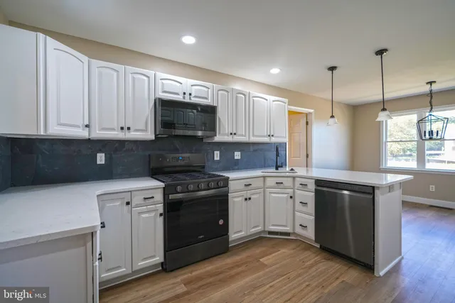 a kitchen with stainless steel appliances granite countertop a stove a sink and a refrigerator