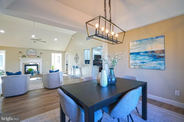 a kitchen with stainless steel appliances granite countertop wooden cabinets a sink dishwasher a stove and a refrigerator with wooden floor