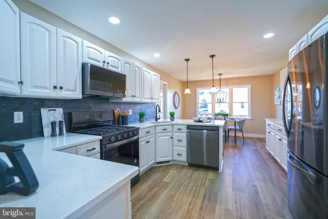 a kitchen with stainless steel appliances granite countertop a sink a stove and cabinets