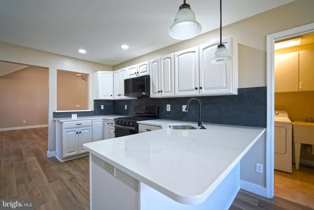 a kitchen with a sink a stove a refrigerator a center island and cabinets