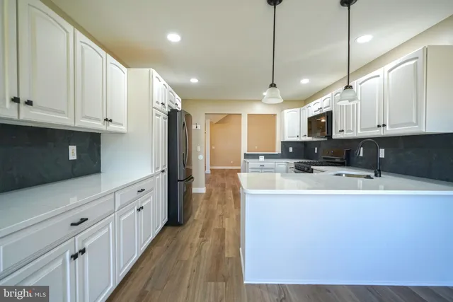 a kitchen with stainless steel appliances granite countertop a sink a stove and refrigerator