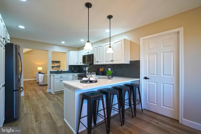 a dining room with furniture a chandelier and wooden floor