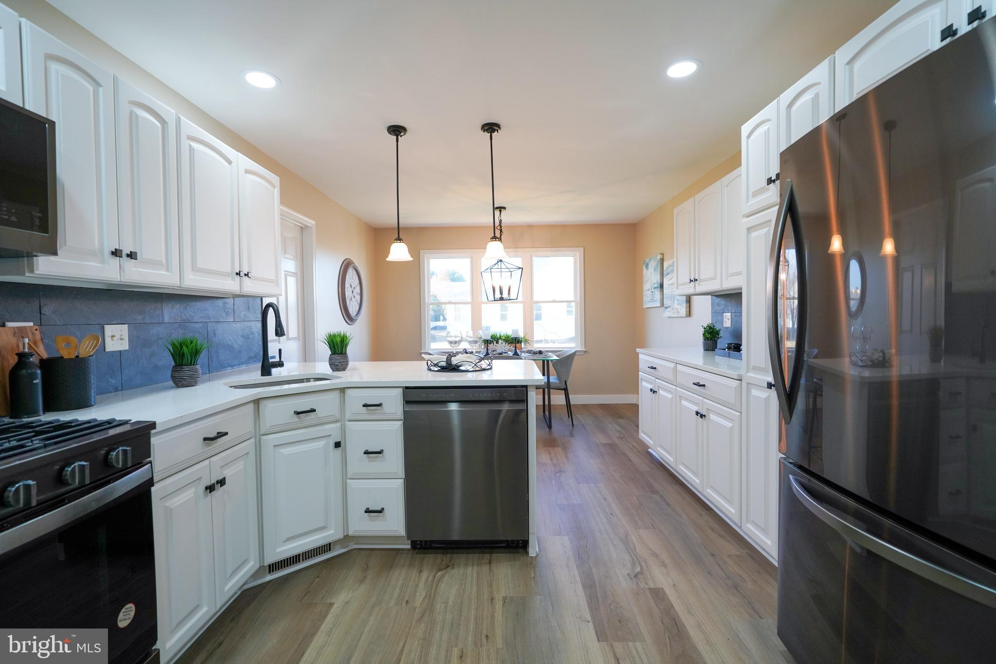 32911 Nassau Loop Lewes, DE 19958 - Photo 22 of 56 a kitchen with stainless steel appliances granite countertop a refrigerator a sink dishwasher a stove and white cabinets with wooden floor
