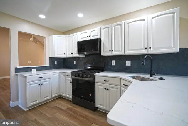a kitchen with stainless steel appliances granite countertop a stove a sink and a microwave