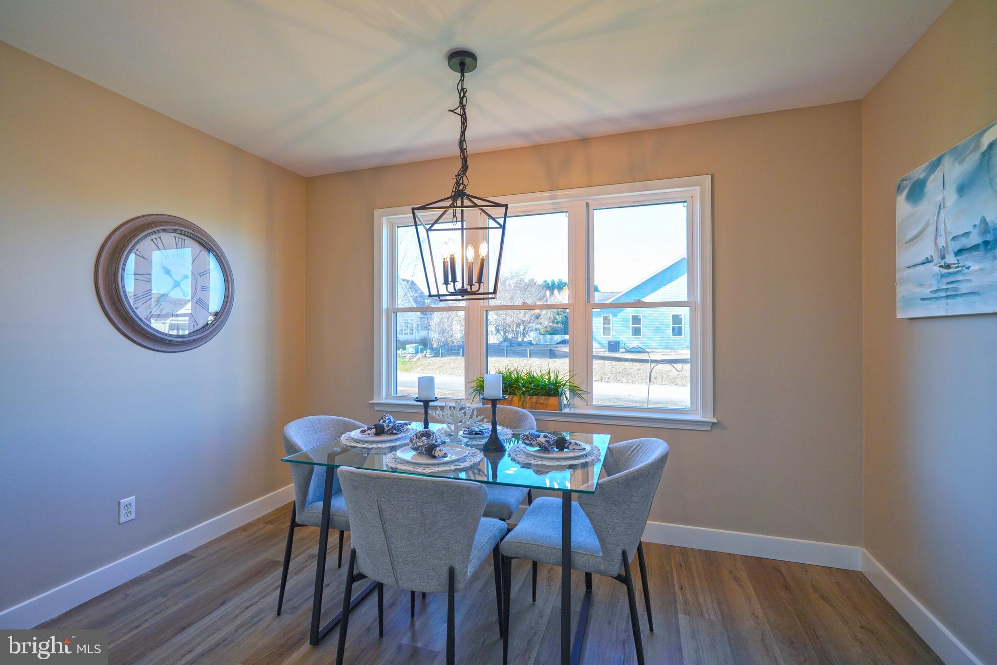 32911 Nassau Loop Lewes, DE 19958 - Photo 23 of 56 a dining room with furniture a chandelier and wooden floor