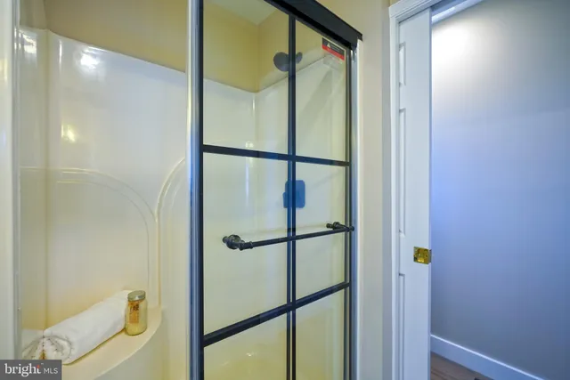an empty room with wooden floor ceiling fan and windows