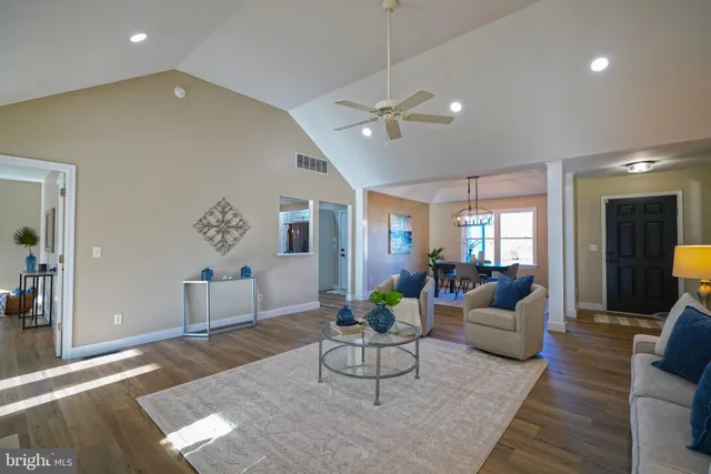 a view of an empty room with wooden floor fireplace and a window
