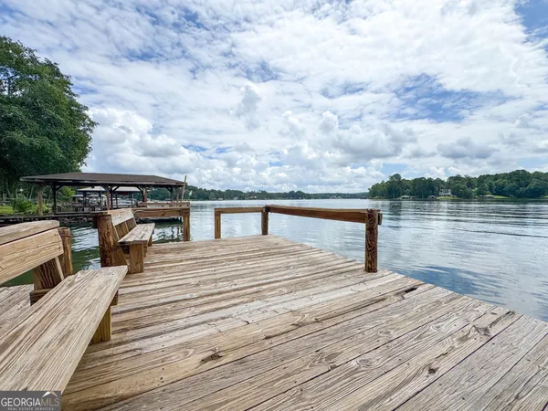 a view of a roof deck with wooden floor and lake view