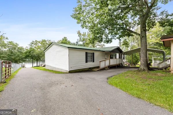 a view of a house with backyard and a tree