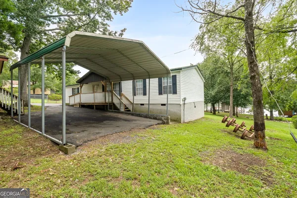 a view of a house with backyard and a tree