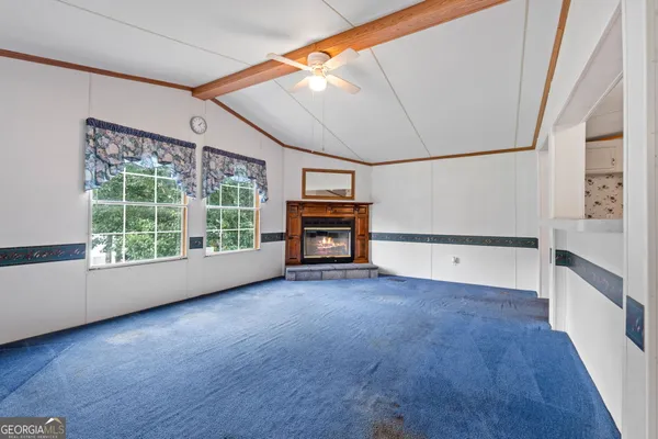 a view of an empty room with a fireplace and a window