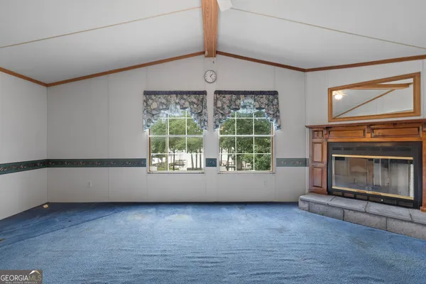 a view of an empty room with a fireplace and a window