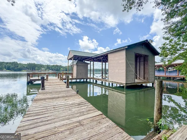 a view of a patio with dining table and chairs with wooden floor and fence