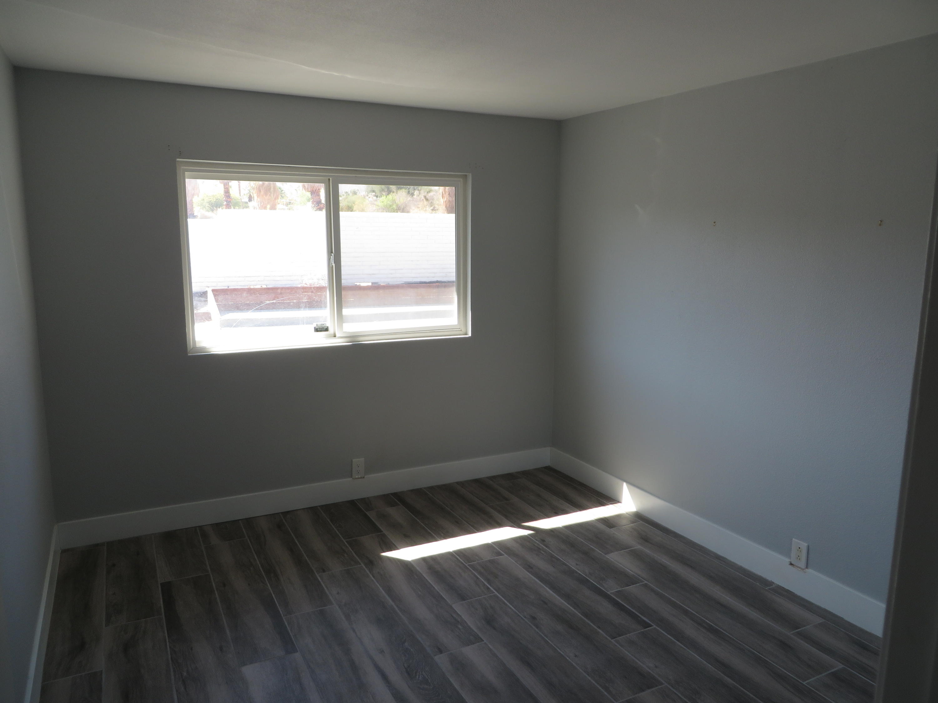 73315 Haystack Road Palm Desert, CA 92260 - Photo 22 of 32 an empty room with wooden floor and windows