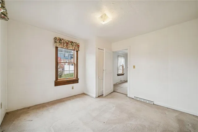 an empty room with windows and closet