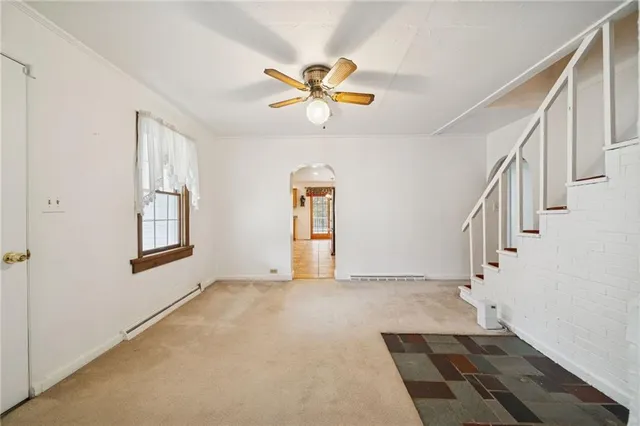 a view of an empty room with wooden floor window and a chandelier