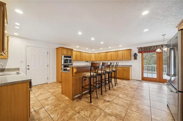 a view of a kitchen with dining area a chandelier outdoor space and windows