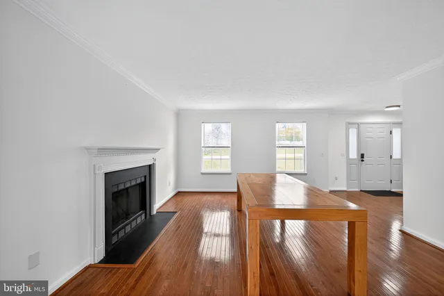 a view of a livingroom with wooden floor and a fireplace
