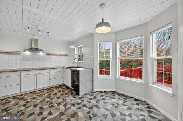 a kitchen with a stove a sink and a window