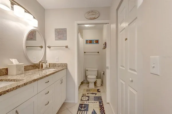 a en suite bathroom with a granite countertop sink and a mirror