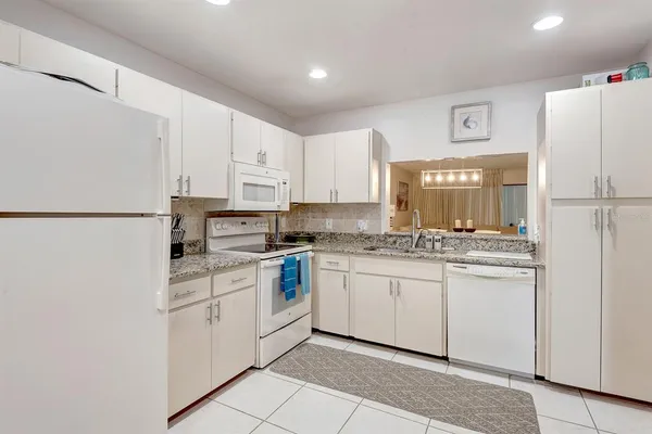 a kitchen with white cabinets and white appliances