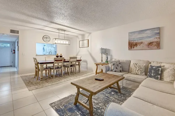 a living room with furniture a rug and a table