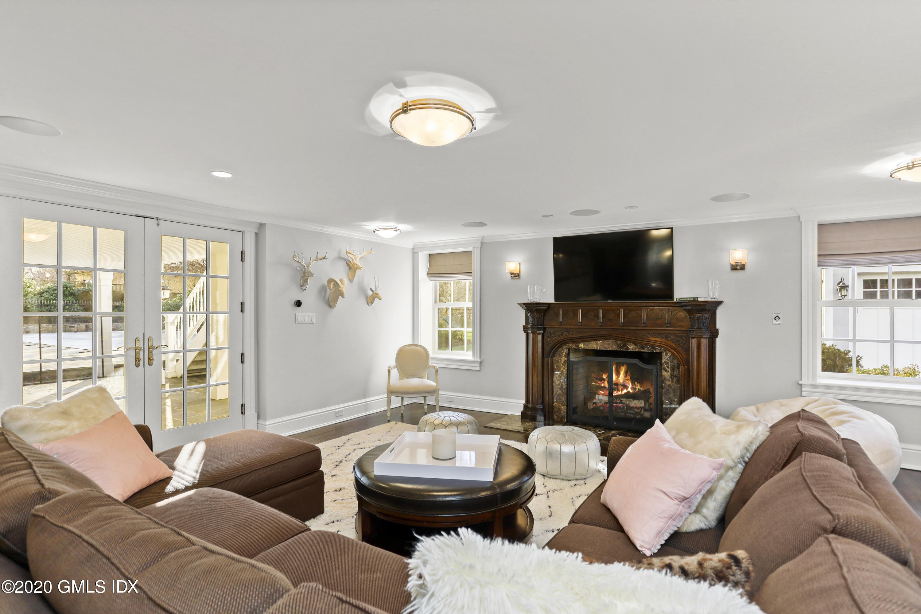 10 Brookridge Drive Greenwich, CT 06830 - Photo 24 of 36 a living room with furniture a fireplace and a large window